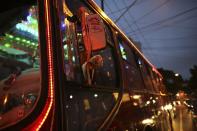 Bus driver Edilson, 45, also known as "Fumassa", rings a bell as he wears a Santa Claus outfit inside an urban bus decorated with Christmas motives in Santo Andre, outskirts of Sao Paulo December 10, 2013. Fumassa dresses as Santa Claus every year while driving his bus. Picture taken December 10. REUTERS/Nacho Doce (BRAZIL - Tags: SOCIETY TRANS9ORT)