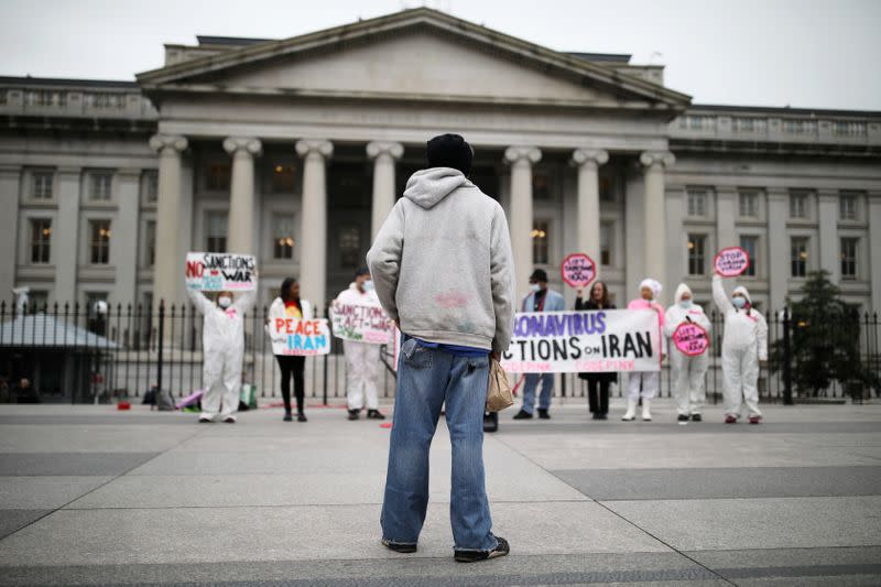 A man looks a at protest against the role that U.S. sanctions plays on Iran and the exacerbation of the coronavirus disease (COVID-19) worldwide outside of the Treasury Department as the World Health Organization said for the first time on Wednesday that i