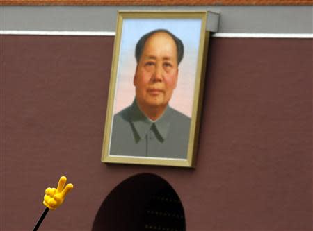 A stick held by a tour guide is seen in front of the large portrait of China's late Chairman Mao Zedong at Tiananmen Gate near the Forbidden City in Beijing, May 13, 2013. REUTERS/Kim Kyung-Hoon