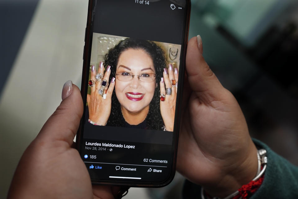 Renee Maldonado shows a photo of her aunt, Journalist Lourdes Maldonado who was shot and killed on Sunday, Jan. 23, at a funeral home during her wake in Tijuana, Mexico, Tuesday, Jan. 25, 2022. Lourdes Maldonado´s murder came 5 days after the murder of freelance photojournalist Margarito Martínez, marking the third killing of a journalist in the country in two weeks. (AP Photo/Marco Ugarte)