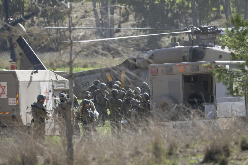A military helicopter transfers a wounded soldier to a military ambulance near the Israeli-Gaza border, in southern Israel, Thursday, Jan. 18, 2024. The army is battling Palestinian militants across Gaza in the war ignited by Hamas' Oct. 7 attack on Israel. (AP Photo/Ohad Zwigenberg)
