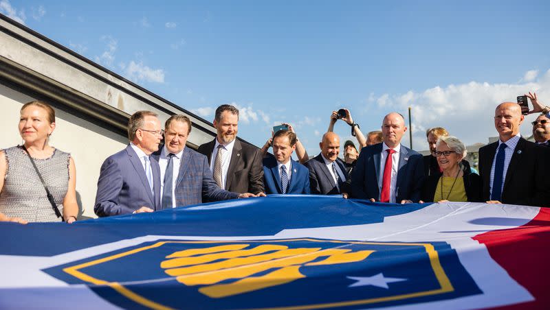 Utah State officials including Utah Gov. Spencer Cox and Senate President Stuart Adams, R-Layton, hold the flag during the raising of the new Utah state flag at the Capitol in Salt Lake City on Wednesday, May 17, 2023.