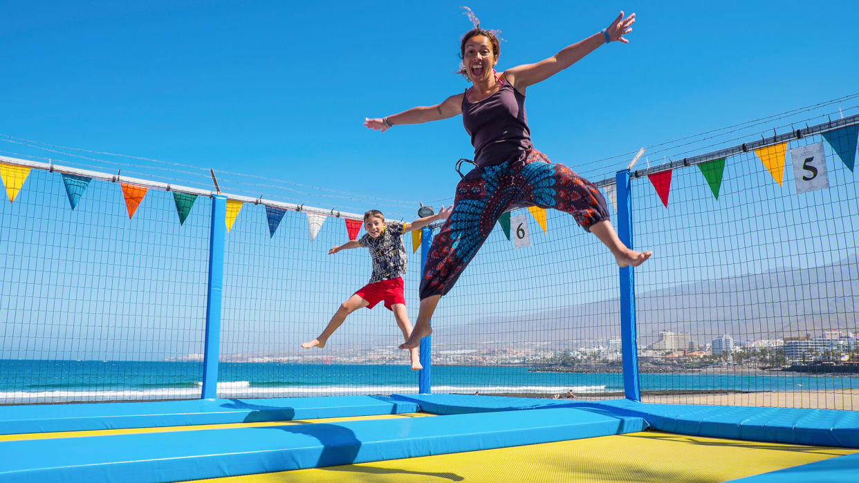 mother and young child son caucasian playing and jumping like crazy having a lot of fun in vacation.