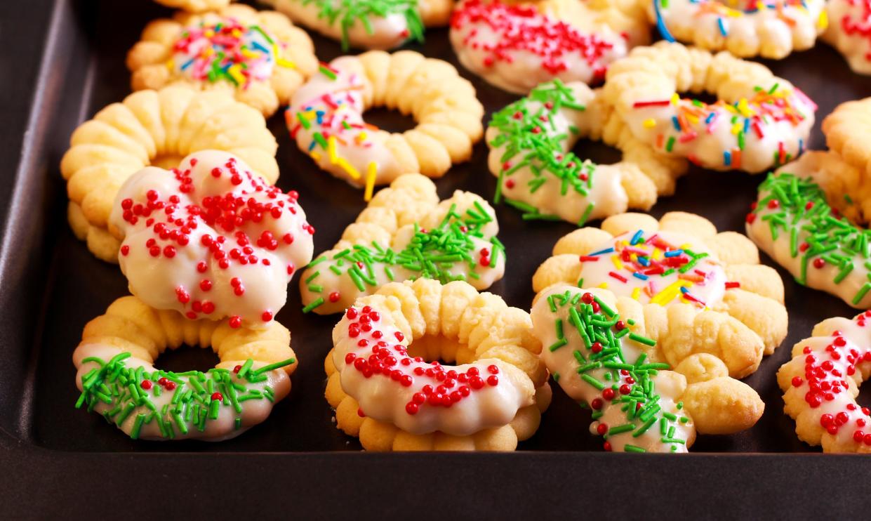 Holiday spritz cookies with icing on tray