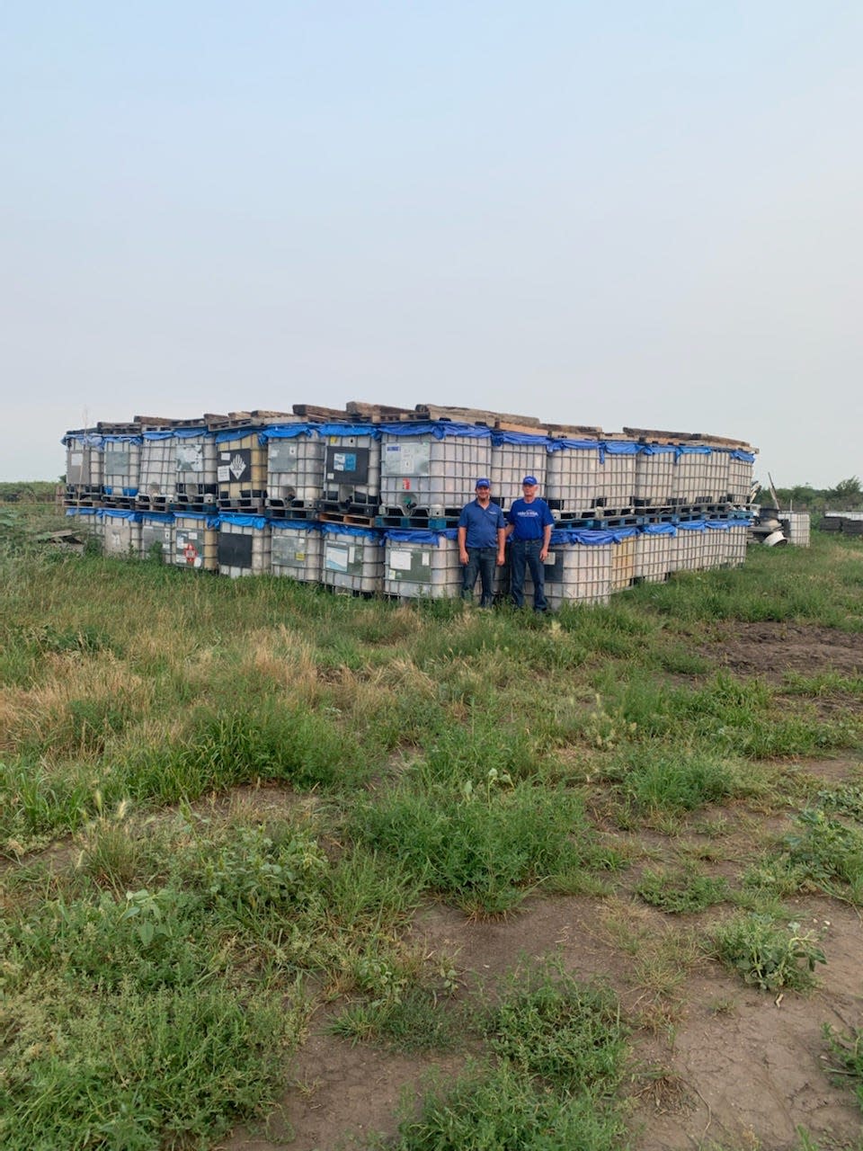 Gerald Schied, right, and his son stand in front of their containers used to collect aluminum cans.