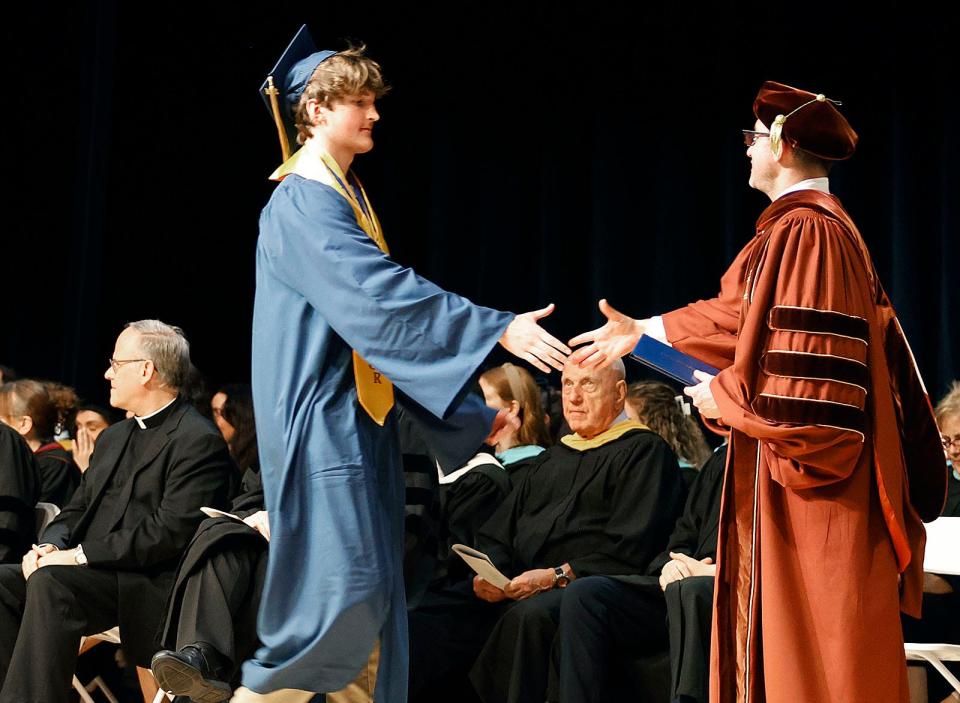 Archbishop Williams High School Valedictorian Ethan Ridings receives his diploma from Principal Michael Volonnino during Archbishop Williams High School's graduation on Thursday, May 23, 2024.