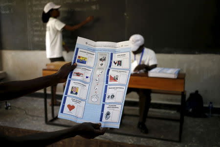 An election official holds up a ballot for scrutiny during vote counting for Burundi's presidential elections in the capital Bujumbura, July 21, 2015. REUTERS/Mike Hutchings