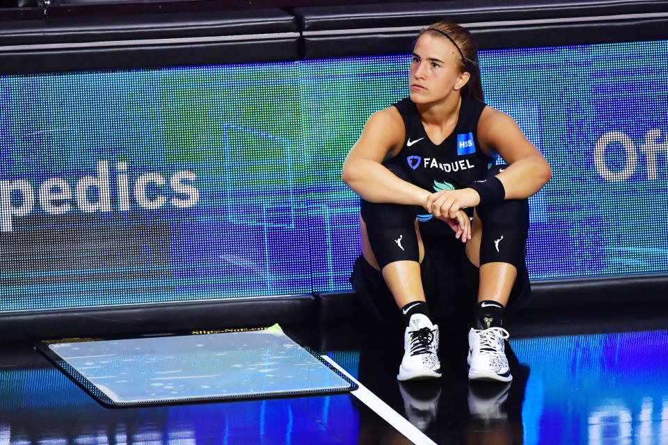 Sabrina Ionescu looks on from the sidelines. 