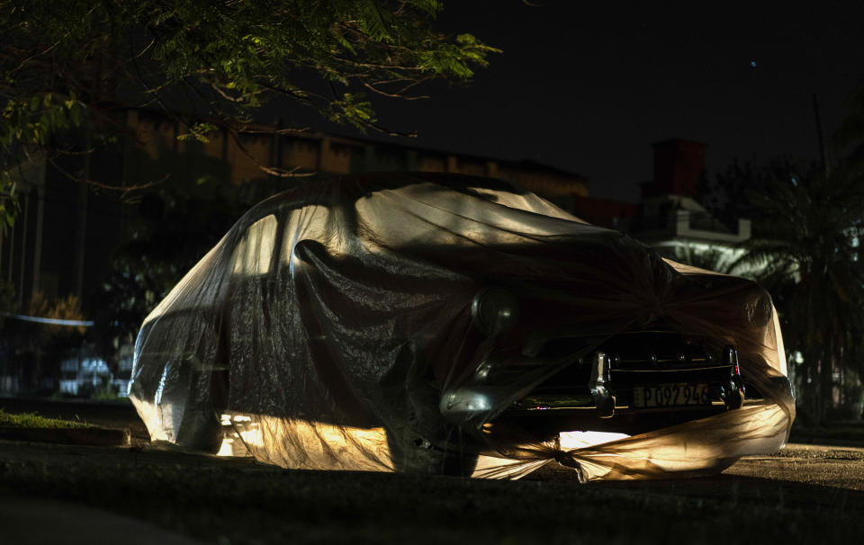 A classic American car is wrapped in plastic to prevent sea salt from corroding it in Havana, Cuba, Tuesday, March 2, 2021. Vintage cars in Cuba are part of daily life with most classic cars being used as taxis and to transport tourists. (AP Photo/Ramon Espinosa)