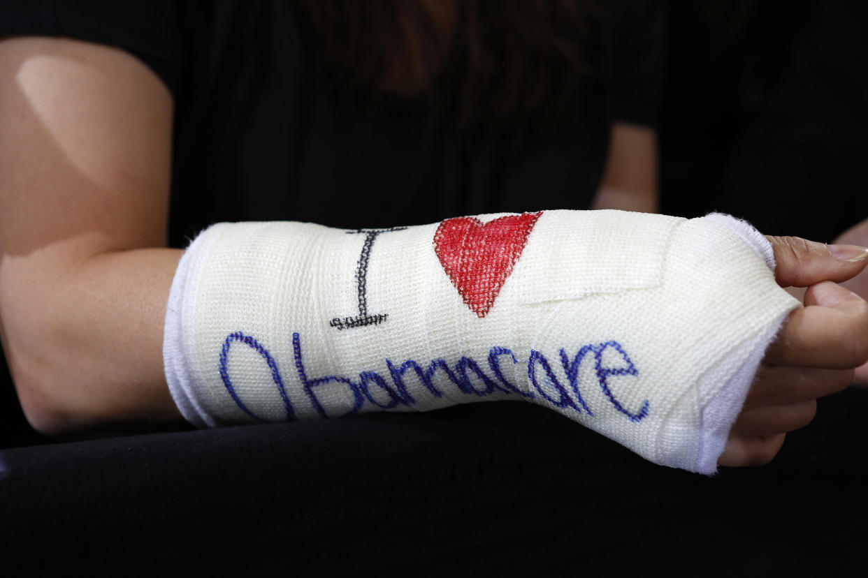 Cathey Park of Cambridge, Massachusetts wears a cast for her broken wrist with "I Love Obamacare" written upon it prior to U.S. President Barack Obama's arrival to speak about health insurance at Faneuil Hall in Boston October 30, 2013.   REUTERS/Kevin Lamarque  (UNITED STATES - Tags: POLITICS)