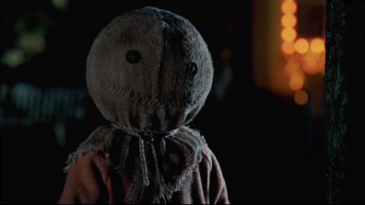  Sam standing outside next to a tree on Halloween in Trick 'r Treat. 