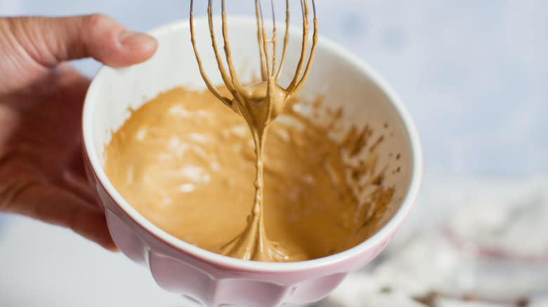 Person whisking whipped coffee in a bowl