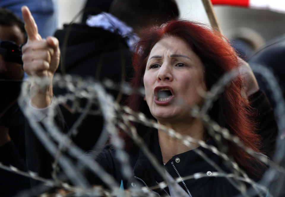 An anti-government protester shouts slogans as she tries to prevent the lawmakers from reaching the parliament building to attend the 2020 budget discussion session, in downtown Beirut, Lebanon, Monday, Jan. 27, 2020. Lebanese security forces scuffled Monday with protesters near the parliament building in downtown Beirut where lawmakers are scheduled to begin a two-day discussion and later approval of the budget amid a crippling financial crisis. (AP Photo/Hussein Malla)