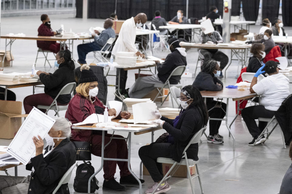 FILE - Workers sort and stack ballots in preparation for scanning as the presidential recount process gets underway Nov. 24, 2020 in the DeKalb County city of Lithonia, Ga. A Georgia prosecutor is expected to seek a grand jury indictment in the coming weeks in her investigation into efforts by Donald Trump and his allies to overturn the former president’s 2020 election loss. Fulton County District Attorney Fani Willis began investigating more than two years ago, shortly after a recording was released of a January 2021 phone call Trump made to Georgia’s secretary of state. (AP Photo/Ben Gray, File)