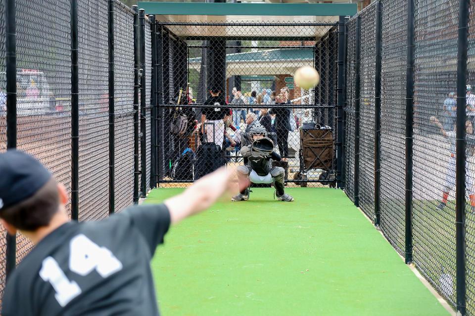 A youth baseball player delivers a pitch inside a cage that is part of Phase II at the Gadsden Sports Complex.