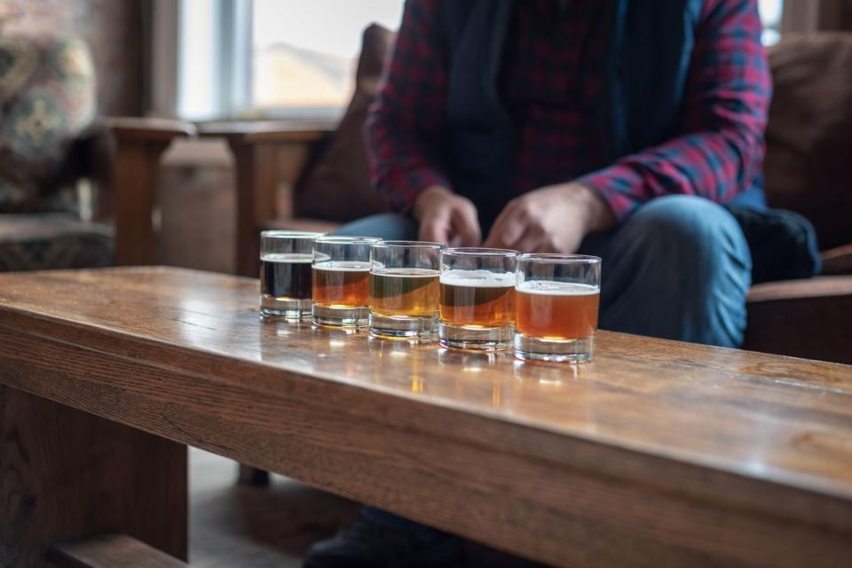 man tasting variety of seasonal craft beers at brewery