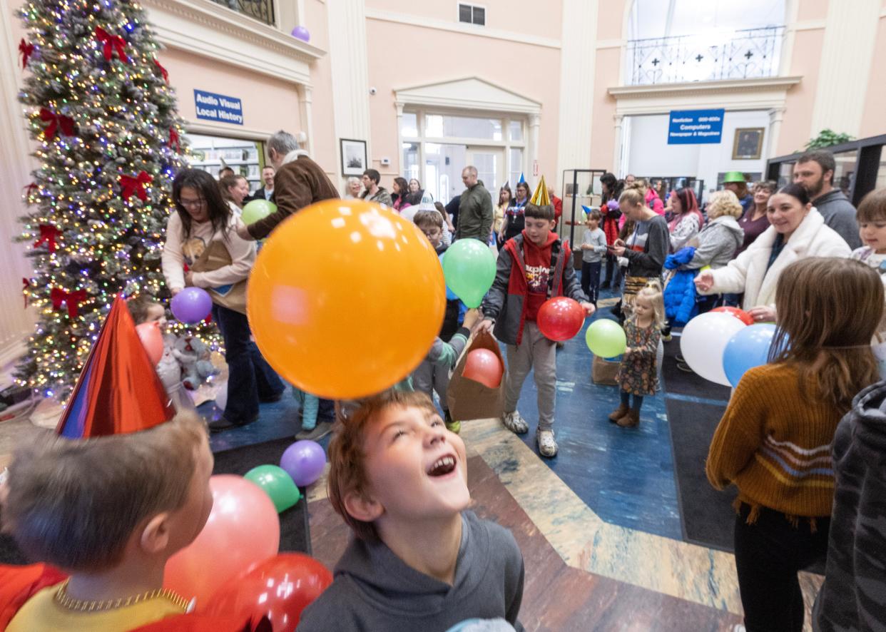 Children play during a noon balloon drop at the Massillon Public Library rotunda during the library's special Noon Year's Eve Party.