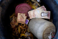 Venezuelan 100 bolivar notes thrown by people in a trash bin are seen at a gas station of the Venezuelan state-owned oil company PDVSA in Caracas, Venezuela. REUTERS/Marco Bello