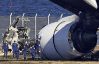 Police investigate the wreckage of Japan Airlines plane at Haneda airport on Thursday, Jan. 4, 2024, in Tokyo, Japan. A transcript of communication between traffic control and two aircraft that collided and burst into flames at Tokyo’s Haneda Airport showed that only the larger Japan Airlines passenger flight was given permission to use the runway where a coast guard plane was preparing for takeoff. (Kyodo News via AP)