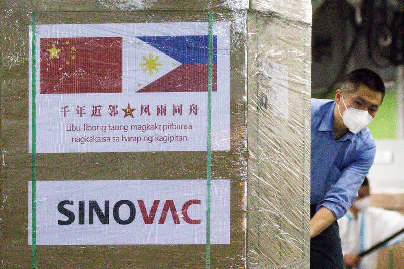 IMAGEN DE ARCHIVO. Un trabajador descarga una caja de vacunas CoronaVac de Sinovac Biotech contra la enfermedad del coronavirus (COVID-19) desde un avión militar chino en la Base Aérea de Villamor en Pasay, en la Gran Manila, Filipinas