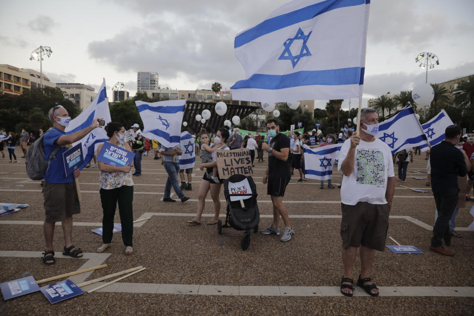 People take part in a protest against Israel's plan to annex parts of the West Bank and Trump's mideast initiative, in Tel Aviv, Israel, Tuesday, June 23, 2020. (AP Photo/Sebastian Scheiner)