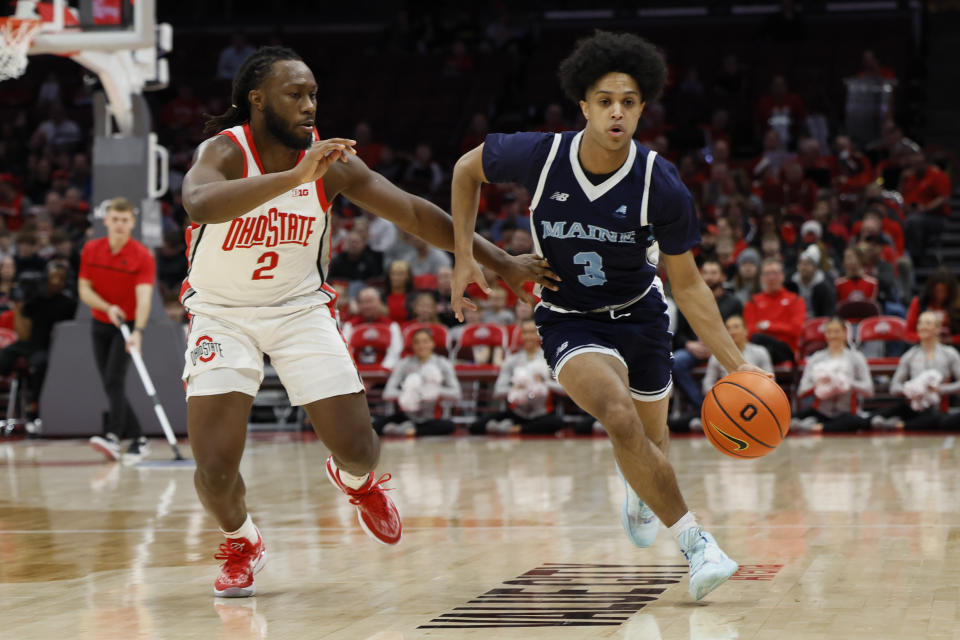 Maine's Jaden Clayton, right, dribbles past Ohio State's Bruce Thornton during the first half of an NCAA college basketball game on Wednesday, Dec. 21, 2022, in Columbus, Ohio. (AP Photo/Jay LaPrete)