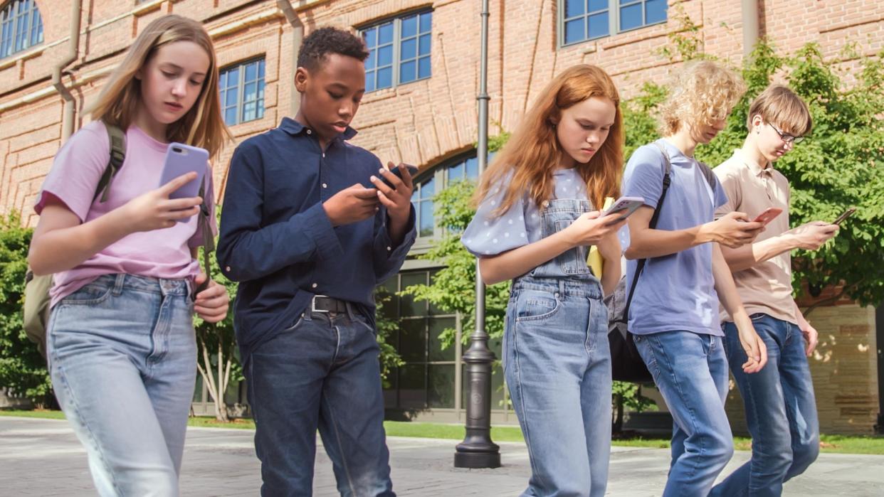  Kids texting on their phones while walking. 