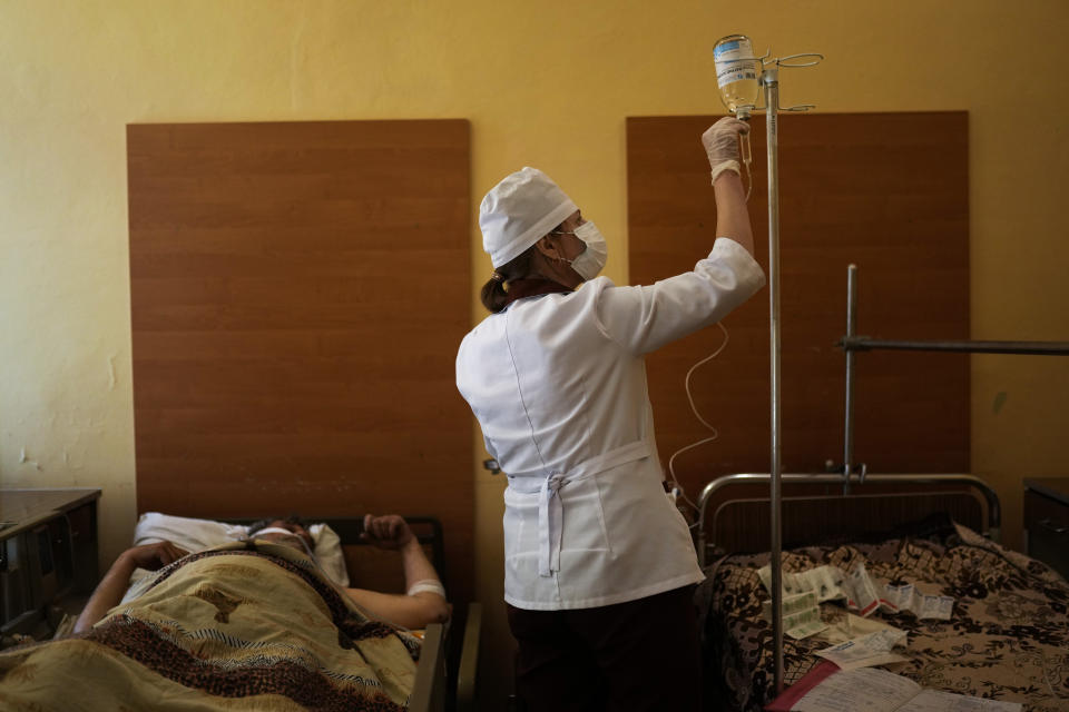 A nurse tends to a patient after he underwent surgery for injuries to his leg and abdomen caused by a mine explosion in Severodonetsk, at Kostyantynivka hospital, in Kostyantynivka, eastern Ukraine, Monday, May 23, 2022. (AP Photo/Francisco Seco)