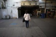 A woman walks along a tunnel on her way to cross the border from Mexicali, Mexico, to Calexico, Calif., Wednesday, July 22, 2020. (AP Photo/Gregory Bull)