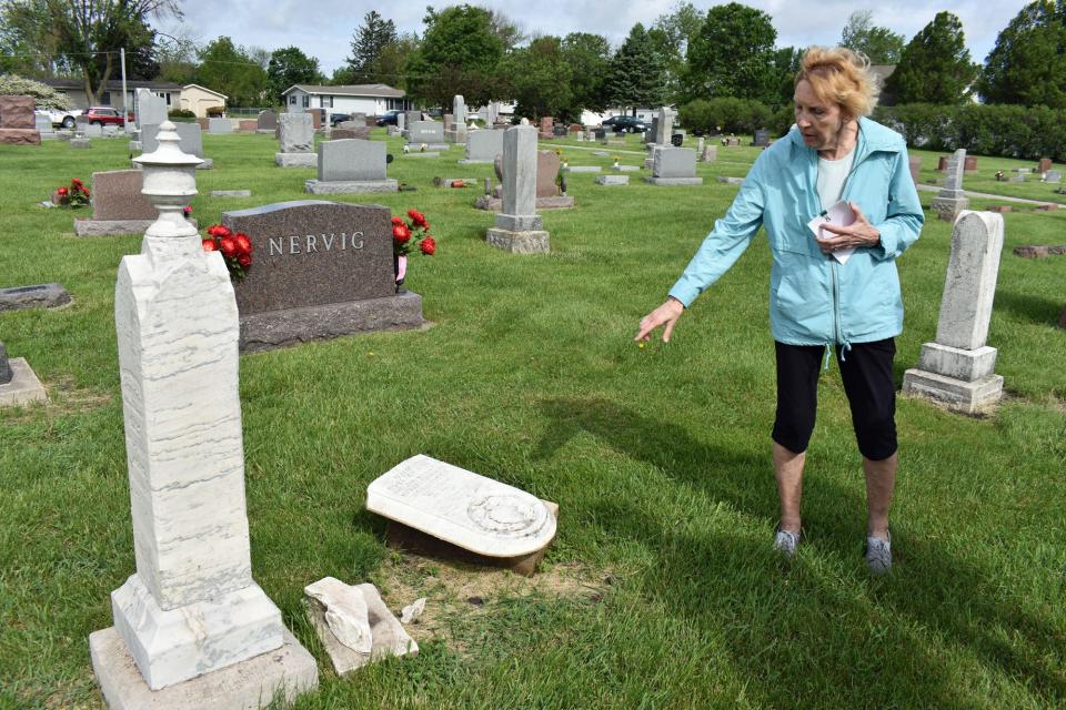 Barb Mallon shows a broken headstone at Bethlehem Lutheran Church Cemetery in Slater. Years of Iowa weather caused damage to the historic stone.