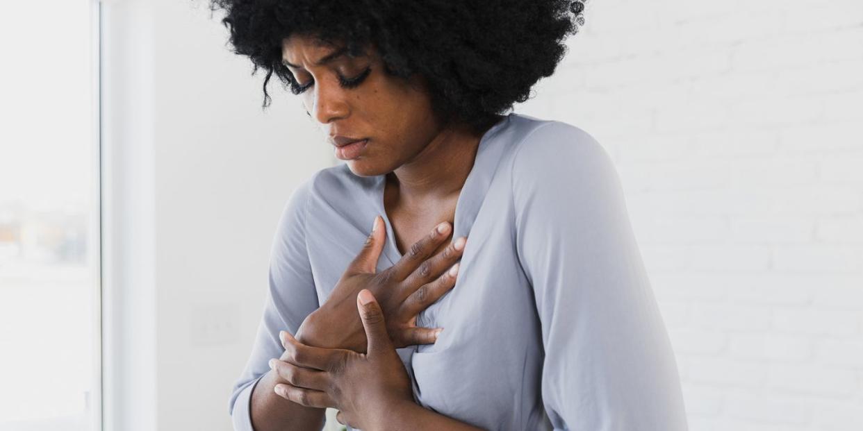 mid adult woman holds chest