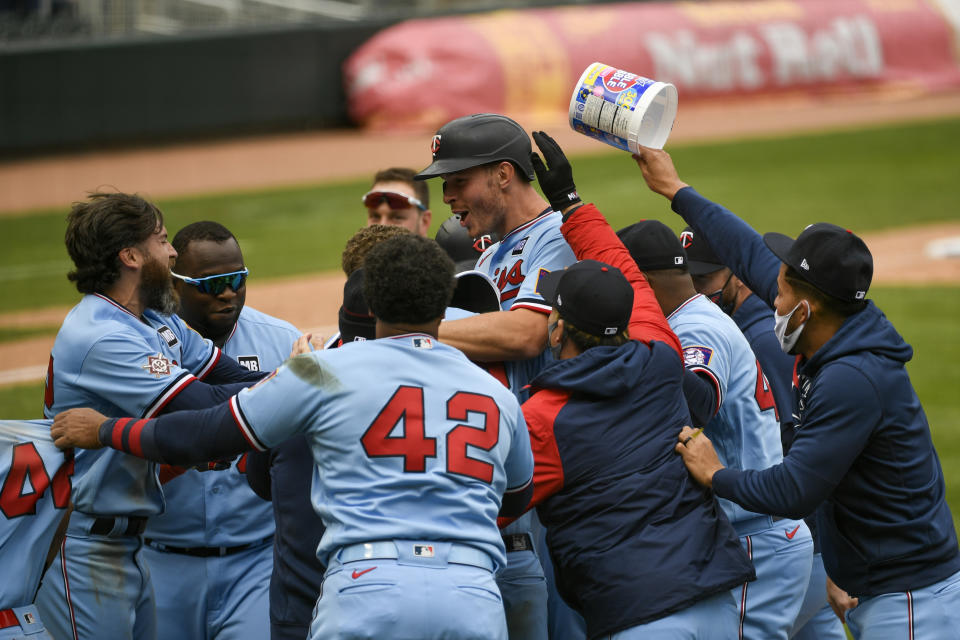 Minnesota Twins' Max Kepler, center with helmet, celebrates with his team after driving in the winning run in the ninth inning of a baseball game against the Boston Red Sox, Thursday, April 15, 2021, in Minneapolis. The Twins won 4-3. (AP Photo/Craig Lassig)