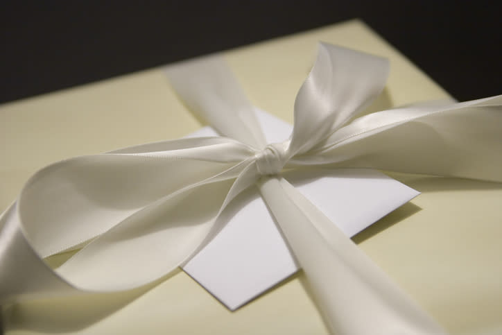 Gift box with a white ribbon and blank card, suggestive of a wedding present