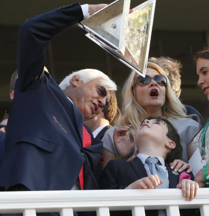 Bob Baffert holds up the Triple Crown Trophy with his son, Bode, and wife Jill. (AP)