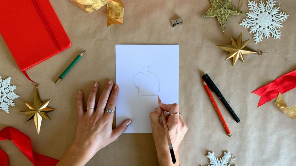 illustrator's hands drawing santa claus