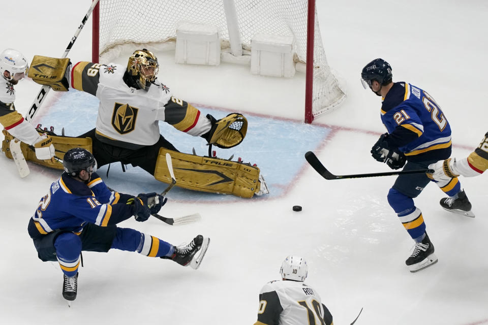 St. Louis Blues' Zach Sanford (12) passes to teammate Tyler Bozak (21) as Vegas Golden Knights goaltender Marc-Andre Fleury (29) defends during the third period of an NHL hockey game Wednesday, April 7, 2021, in St. Louis. (AP Photo/Jeff Roberson)