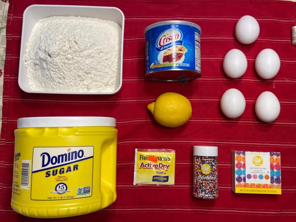 Flour, sugar, crisco, a lemon, a yeast packet, bottle of sprinkles, 5 eggs, and a box of food coloring.