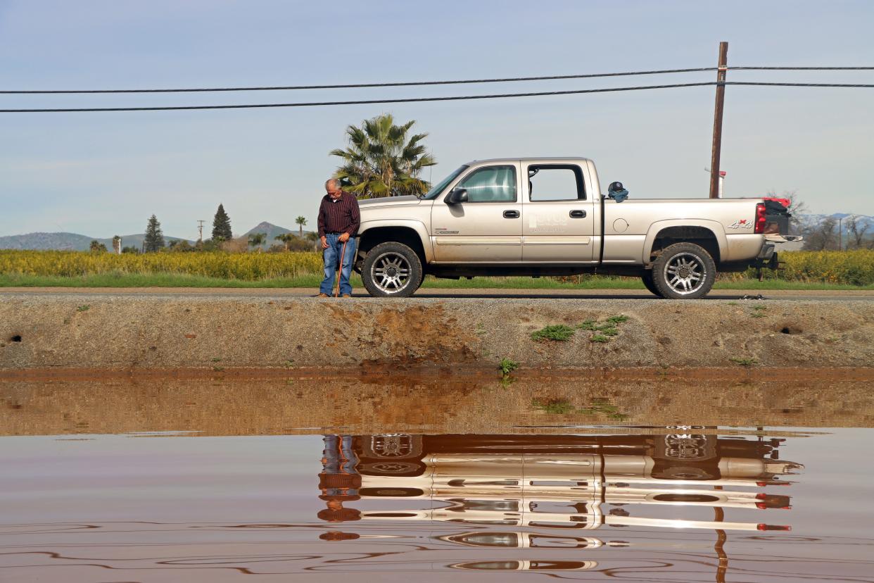 Victor Sanchez stands leans up against his truck after taking in the damage his property saw following a series of storms last week. His family has owned the property, now mostly under water, for over 40 years.