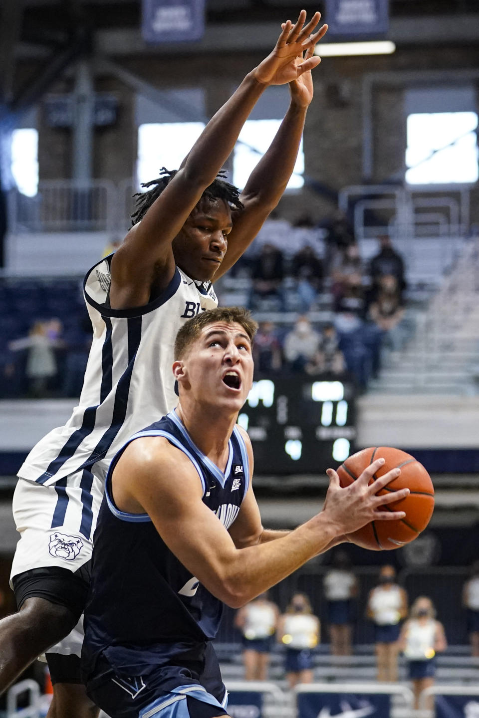 Villanova guard Collin Gillespie (2) looks to shoot under Butler guard Chuck Harris (3) in the first half of an NCAA college basketball game in Indianapolis, Sunday, Feb. 28, 2021. (AP Photo/Michael Conroy)