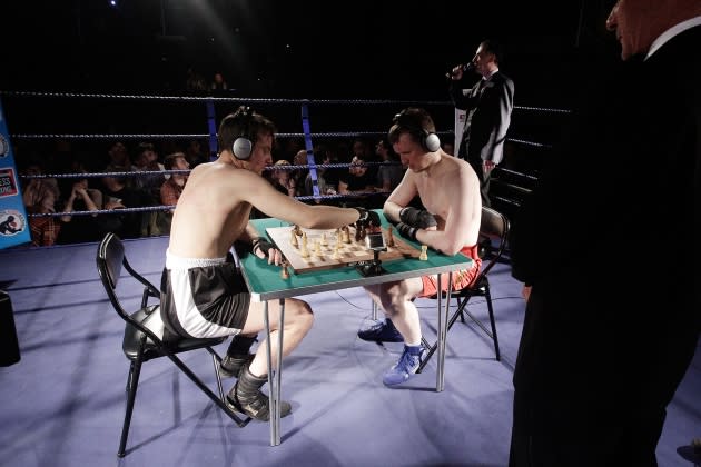 Boxer stuggling with chess game, Stock image