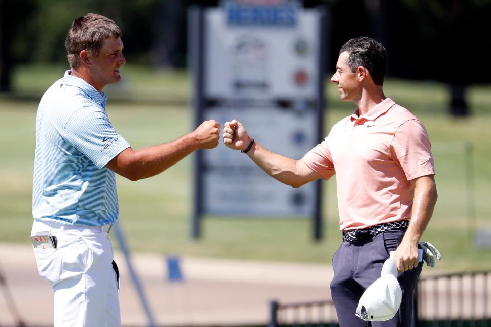 Bryson DeChambeau and Rory McIlroy fist bump on the 18th green during the final round of the Charles Schwab Challenge golf tournament at Colonial Country Club.