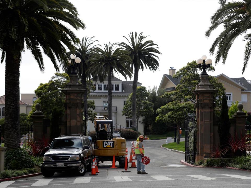 A construction worker stands in front of a gate leading into the Presidio Terrace (AP)