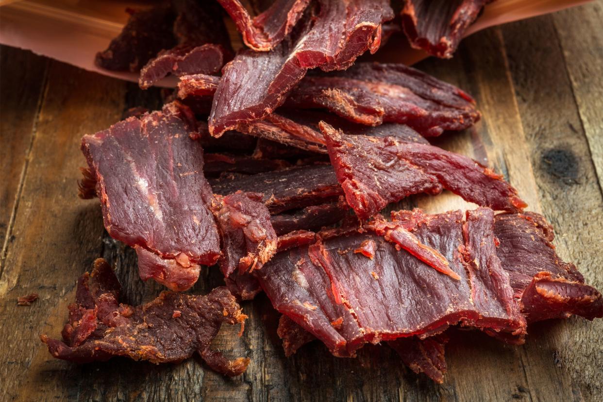 Closeup of several pieces of beef jerky on a rustic wooden table