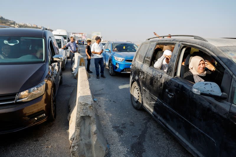 Israeli troops check cars at a checkpoint near a shooting scene in Huwara