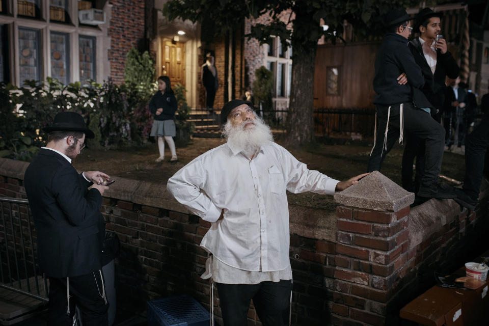 A Chabad-Lubavitch Orthodox Jew looks up in the Brooklyn borough of New York as a helicopter patrols the area during an event held for solidarity and prayer for Israel, on Oct. 9, 2023, two days after the brutal attack by Hamas militants in southern Israel. (AP Photo/Andres Kudacki)