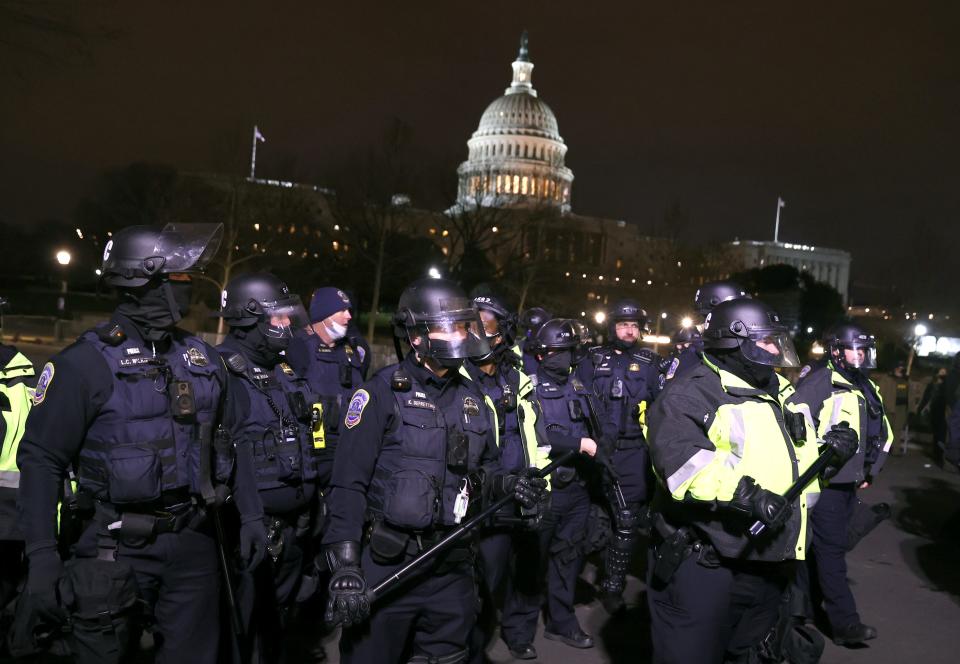 Police officers in riot gear monitor protesters gathering at the U.S. Capitol on Jan. 6 in Washington.