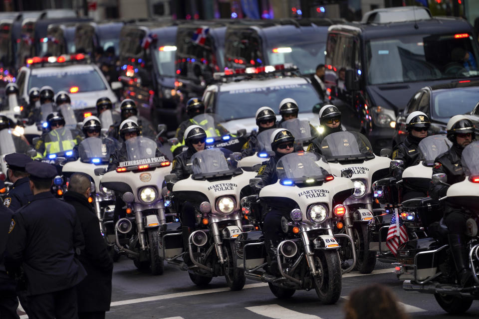 Motorcycle police from various jurisdictions lead an escort for the hearse carrying NYPD Officer Wilbert Mora's casket after Mora's funeral service at St. Patrick's Cathedral, Wednesday, Feb. 2, 2022, in New York. For the second time in under a week, police converged on New York City's St. Patrick's Cathedral to pay tribute to a young officer gunned down while answering a call for help in Harlem. Mora was shot along with Officer Jason Rivera on Jan. 22 while responding to a call about a domestic argument in an apartment. (AP Photo/John Minchillo)