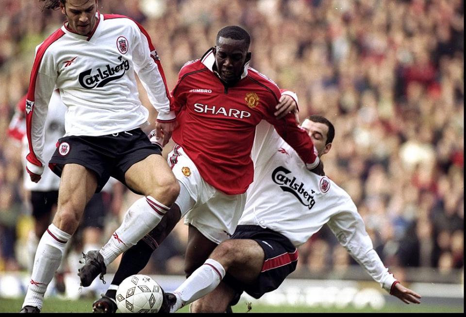 Dwight Yorke is taken out by Patrik Berger and Steve HarknessGetty