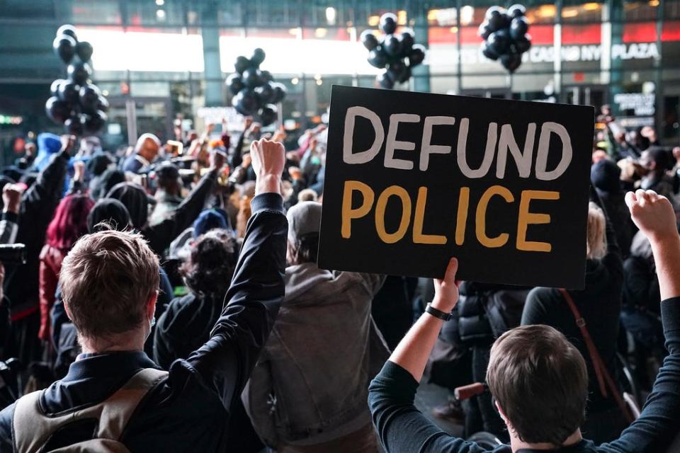 A protester holds a sign that reads "Defund Police" during a rally for the late George Floyd outside Barclays Center, Wednesday, Oct. 14, 2020, in New York.