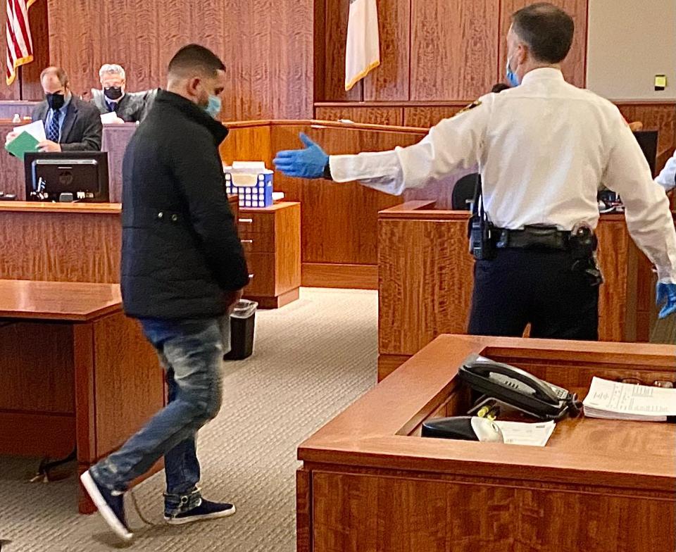 Nelson Coelho, seen here being led out of the courtroom after being arraigned on a murder charge in Bristol County Superior Court in Fall River, is accused of killing convenience store owner Lal Mahaseth.